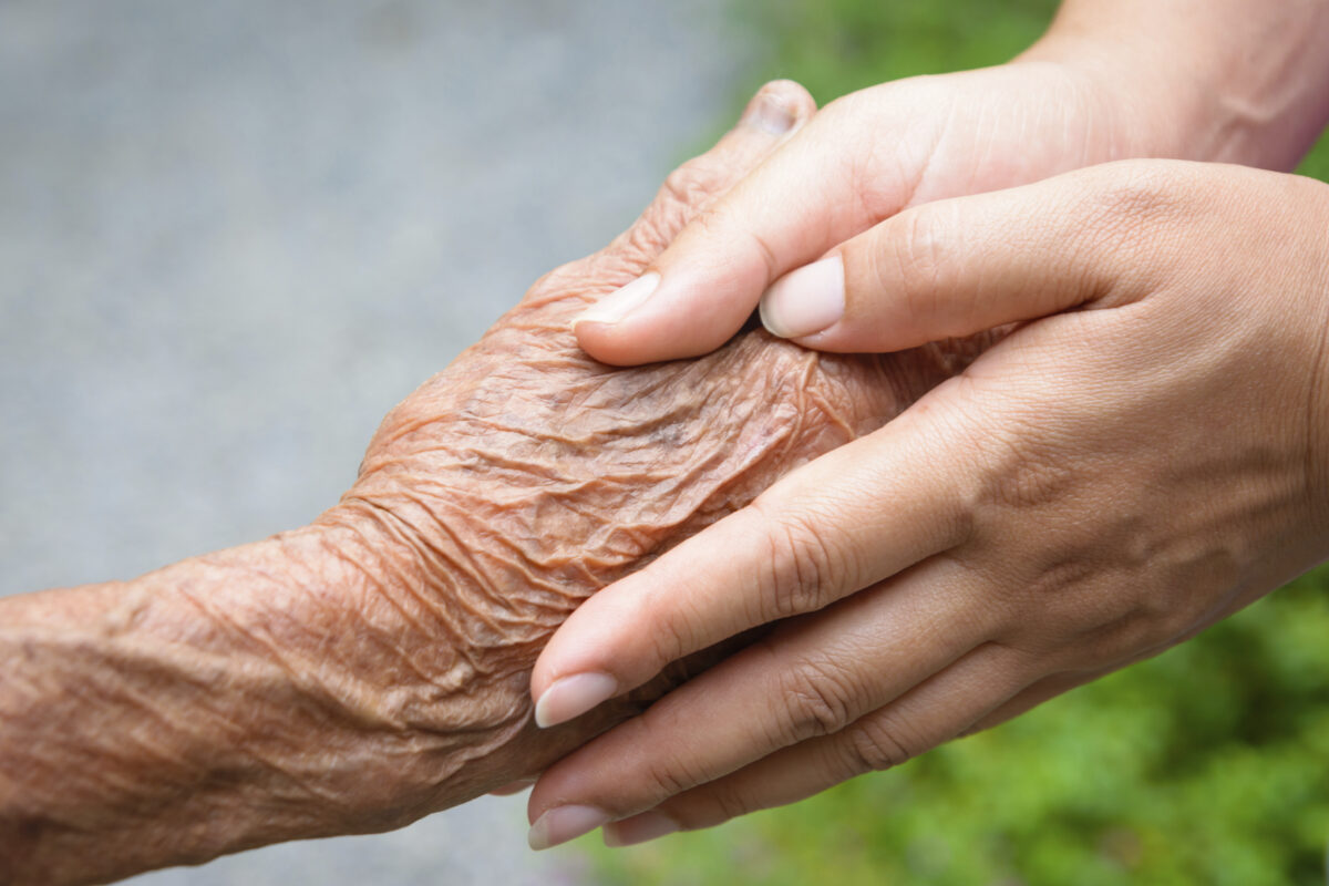 Senior and young holding hands
