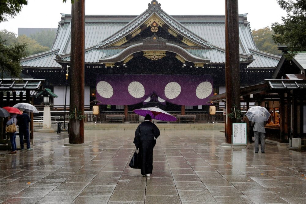 A visitor in a kimono bows at the Yasukuni Shrine in Tokyo