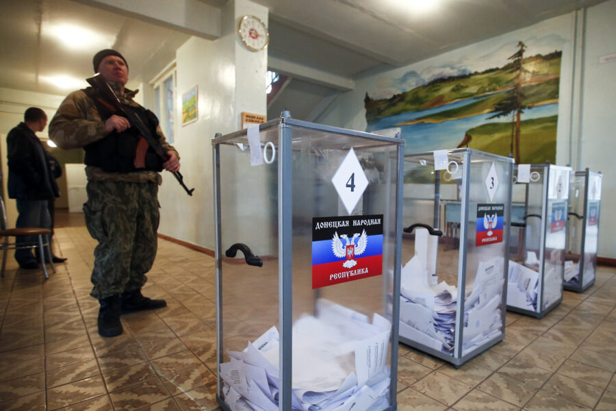 A pro Russian separatist stands guard during the self proclaimed Donetsk People's Republic leadership and local parliamentary elections at a polling station in the settlement of Telmanovo