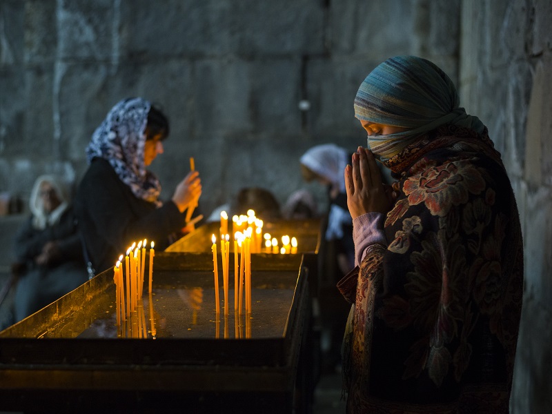 Armenian woman praying at Tatev Monastery in Armenia