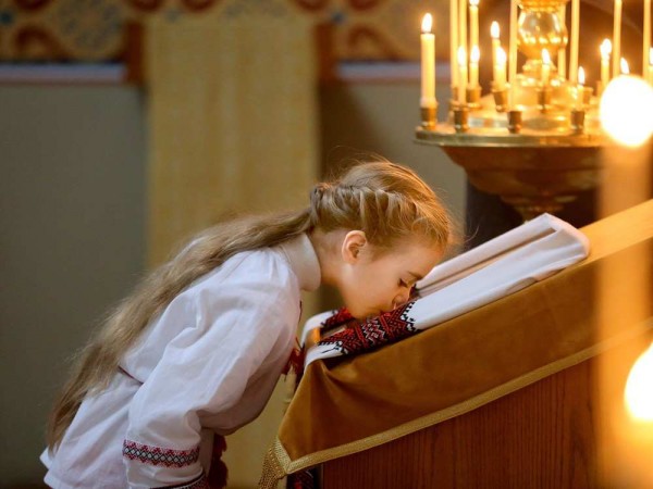 A young girl kisses the virgin mary at the front of the ch 600x450