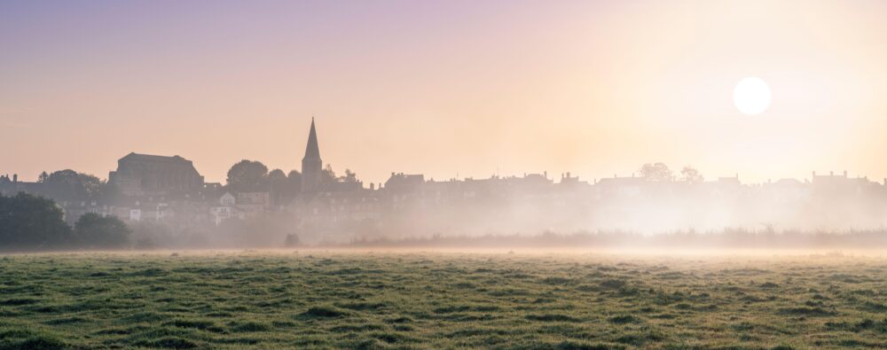 Saturday 9th September 2023. Malmesbury, Wiltshire, England With high temperatures in Wiltshire set to break over the weekend, after a humid night, the sun burns through the early morning mist that drifts across the fields overlooking the hillside town