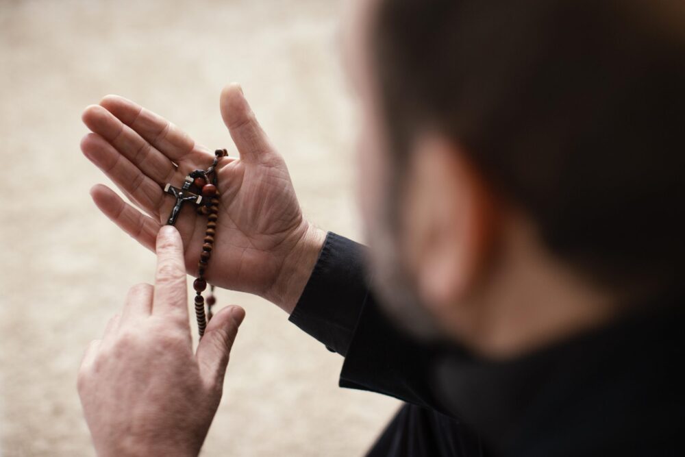 Religious man praying indoors 1 scaled