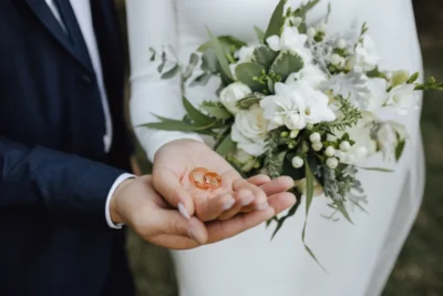 Wedding bands hands bride groom with beautiful wedding bouquet made greenery white flowers